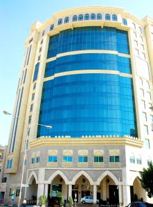 un grande edificio con finestre blu sopra di Grand Regal Hotel a Doha