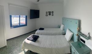 a room with two beds and a window at Casa maría in Costa Teguise