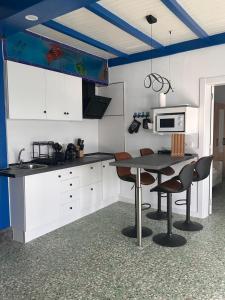 a kitchen with white cabinets and a table with chairs at Casa maría in Costa Teguise