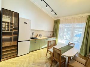 a kitchen with a table and a white refrigerator at Гостевой дом Burabay Grand Village in Borovoye