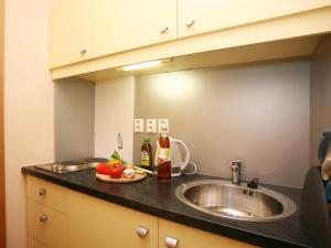 a kitchen counter with a sink and two bottles of alcohol at Apartments City Centre in Bratislava