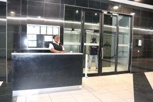 a woman standing behind a counter in a building at C&J Luxe Apartments in Windhoek +33 photos