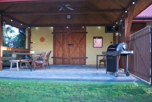 a patio with a grill and a table and chairs at Agroturystyka pod Czarną Sosną in Biały Ług