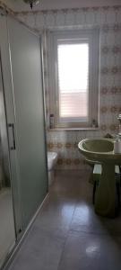a bathroom with a toilet and a sink and a window at Twins in Solarino