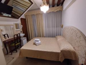 a small room with a bed and a table with towels at Alloggi Acquavita - checkin at "Alloggi SS Giovanni e Paolo" in Venice