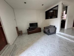 a living room with a chair and a television at Un lugar muy bien ubicado in Morelia