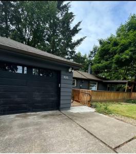un garaje con una puerta de garaje negra delante de una casa en Portland SW Hill Home, en Portland