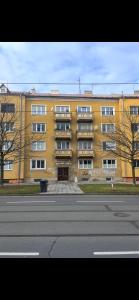 a large yellow building on the side of a street at Amazing Apartment Wolkerova in Olomouc