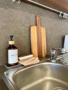 a sink with a bottle of soap and a wooden cutting board at Amazing Apartment Wolkerova in Olomouc