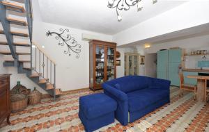 a living room with a blue couch and stairs at Casa Barbara in Amalfi