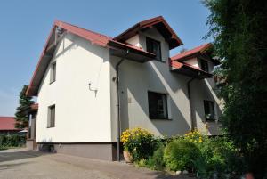 a white building with a red roof at Agroturystyka pod Czarną Sosną in Biały Ług