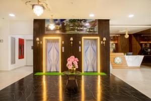 a lobby with two doors and a vase of flowers on a table at The Monarch Hotel Bagalur IT Park in Bengaluru +54 photos