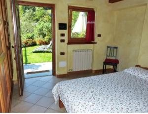 a bedroom with a bed and a view of a yard at Au Coeur in Verrayes