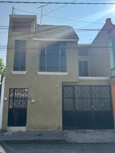 a house with two garage doors on a street at Un lugar muy bien ubicado in Morelia