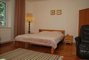 a bedroom with a bed and a black chair at Agroturystyka pod Czarną Sosną in Biały Ług