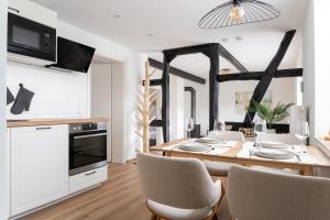 eine Küche und ein Esszimmer mit Tisch und Stühlen in der Unterkunft Ferienhaus Ahorn, wunderschöne, neue Wohnungen, ideal für Ausflüge ins Phantasialand, die Städte Köln, Brühl und Bonn oder die Eifel in Weilerswist