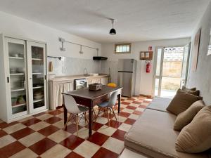 eine Küche und ein Wohnzimmer mit einem Tisch und einer Couch in der Unterkunft Villa Odetta - appartamento Limonaia in Torre Colimena