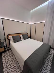 Un dormitorio con una gran cama blanca en una habitación. en Domus MARIA VITTORIA, en Nápoles