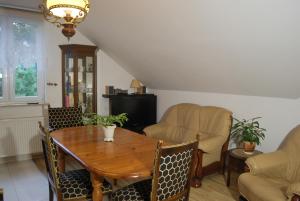 a dining room with a wooden table and chairs at Agroturystyka pod Czarną Sosną in Biały Ług