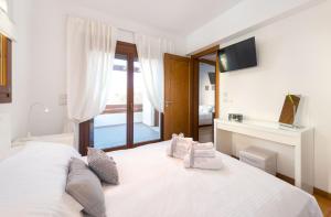 een slaapkamer met een groot wit bed met een raam bij Katerina Boutique Villa in Rhodos-stad