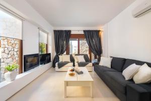 a living room with a black couch and a fireplace at Katerina Boutique Villa in Rhodes Town