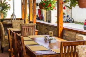 a wooden table and chairs on a patio at Ötösfogat Panzió in Siófok
