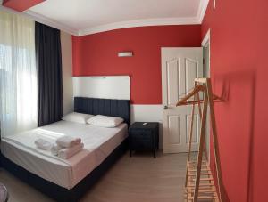 a bedroom with a bed with red walls and a ladder at Grand asia otel in Seferihisar +13 photos