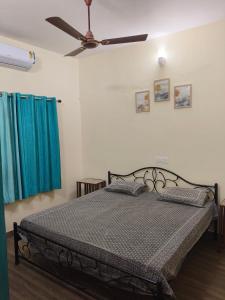 a bedroom with a bed with a ceiling fan at Cloud 9 Residency in Dehradun