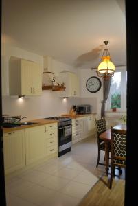 a kitchen with a table and a clock on the wall at Agroturystyka pod Czarną Sosną in Biały Ług