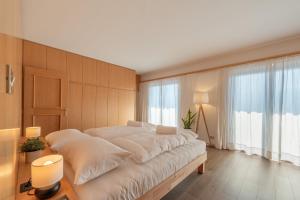 a bedroom with a large bed with white sheets at Apartments Villa Vardia in Caldaro +51 photos