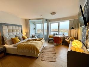 a bedroom with a large bed with a desk and a room with a desk at Schleiblick in Schleswig