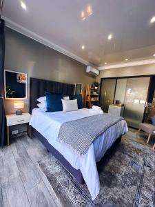 a bedroom with a large bed with blue pillows at Lemon & Blue in Welkom