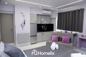 a living room with a couch and a kitchen at Modern studio in the city center in Chalkida