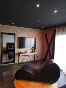 a living room with a couch and a large mirror at Avec toi suite spa La Secrète in Barlin