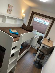 a small bedroom with a bunk bed and a desk at FeWo Wieko Plauen H1 3 OG links Family Appartement XL in Plauen