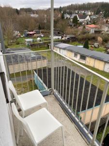 a balcony with two chairs and a view of a field at FeWo Wieko Plauen H1 3 OG links Family Appartement XL in Plauen