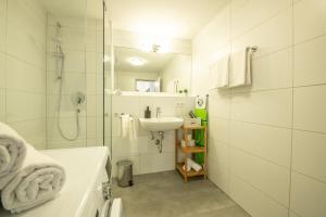 a white bathroom with a sink and a shower at Apartmenthaus Markdorf in Markdorf +62 photos