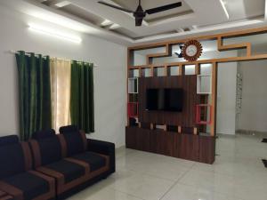 a living room with a couch and a tv at Ashvis cottage in Thekkady