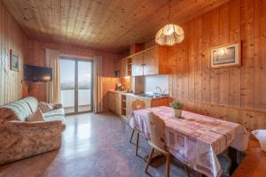 a living room with a table and a couch and a kitchen at Apartments Burgunderhof in Termeno