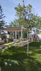 un gazebo in un parco con un albero di VILLA DEI GELSI Punta prosciutto a Punta Prosciutto