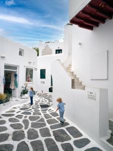 two children playing on a stone walkway in a building at La Maison Kalogera in Mikonos