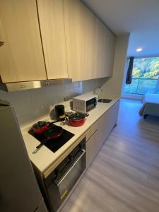 a kitchen with two bowls on a stove with a microwave at Excelente Depto tipo Estudio in Viña del Mar