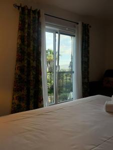 a bedroom with a bed and a large window at Quinta Verde Sintra - Casa de Campo in Sintra