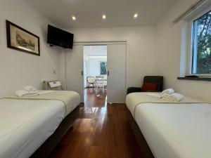a room with two beds and a living room at Quinta Verde Sintra - Casa de Campo in Sintra