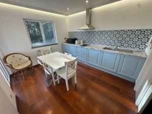a kitchen with blue cabinets and a table and chairs at Quinta Verde Sintra - Casa de Campo in Sintra