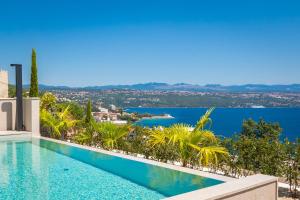 een zwembad met uitzicht op het water bij Heaven Apartment with swimming pool in Opatija