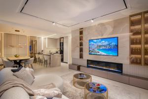 een woonkamer met een open haard en een tv aan de muur bij Heaven Apartment with swimming pool in Opatija