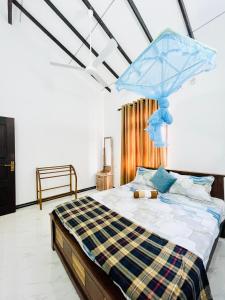 a bedroom with a bed with a blue umbrella on it at Fanisha Family Villa and Restaurant in Negombo