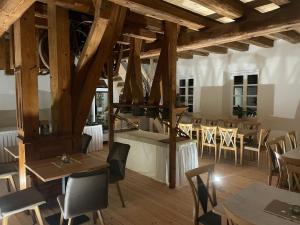 a room with tables and chairs and wooden ceilings at Beim Mühlenwirt in Bobenthal