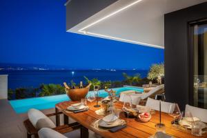 een eetkamer met een tafel en uitzicht op de oceaan bij Heaven Apartment with swimming pool in Opatija